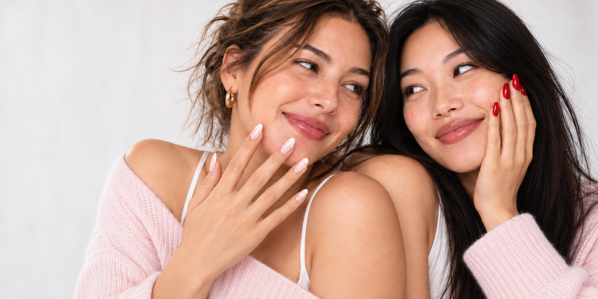 Two women wearing ivory and cherry-red manicures.